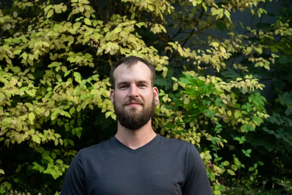 Une photographie de Nicola devant de la végétation
